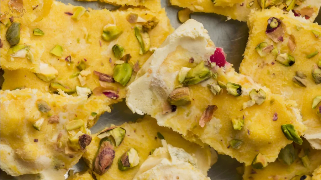 Persian saffron ice cream served with traditional saffron sweets and topped with pistachios, showcasing rich Persian flavours.