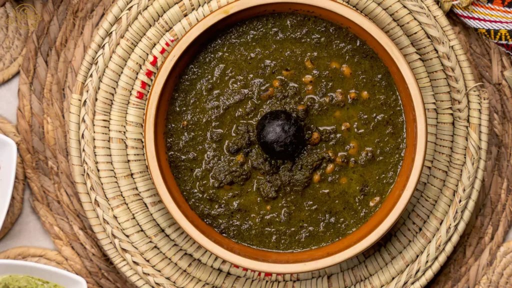Persian stews Ghormeh Sabzi with kidney beans and dried lime served in a traditional Iranian setting