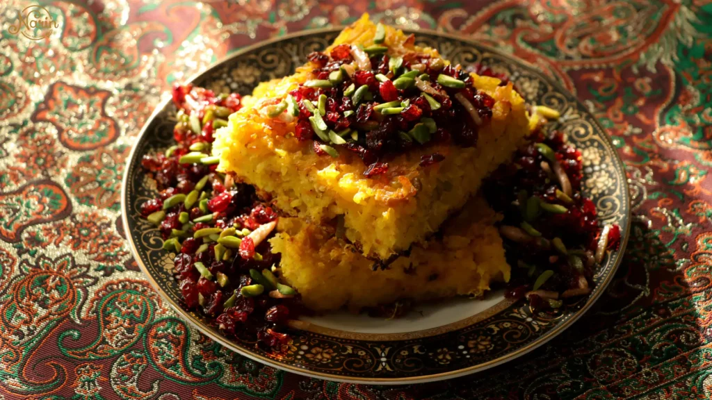 A plate of crispy Tahchin (Persian saffron rice cake) garnished with barberries and pistachios, a highly recommended dish to order at Narin Persian Restaurant.